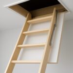 Compact wooden loft access ladder extending into an open ceiling hatch