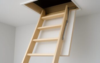 Compact wooden loft access ladder extending into an open ceiling hatch